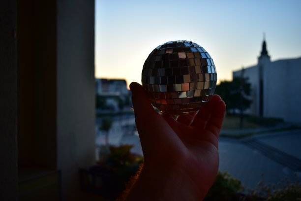 夕阳下手里拿着迪斯科球图片下载