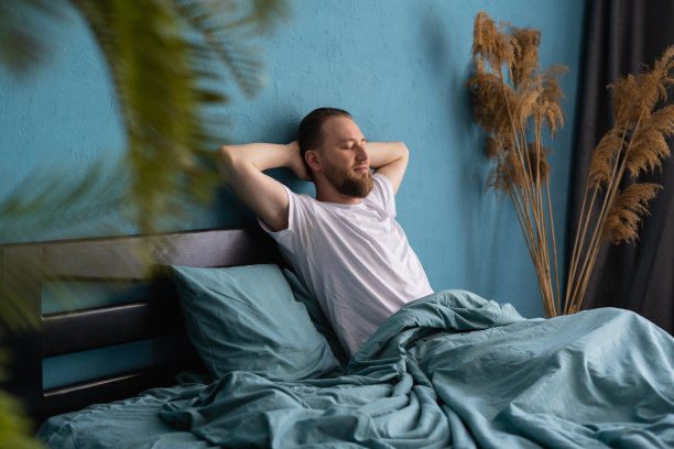 清晨醒来的大胡子男子在公寓的床上放松地休息图片下载