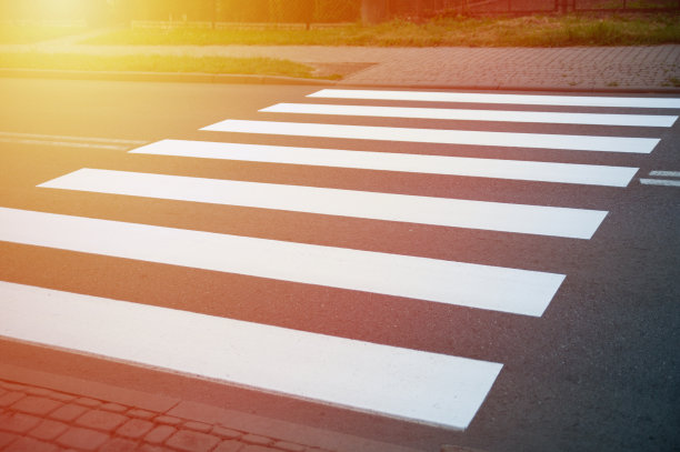 人行横道，黑色沥青上的白色条纹，斑马线的道路标记，过马路的地方，交通规则图片下载