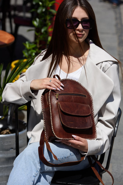 部分照片的女人与一个棕色皮革背包与古董和复古的外观。在户外的照片图片下载