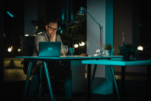 商人带着沉思和担忧的表情看着笔记本电脑图片下载