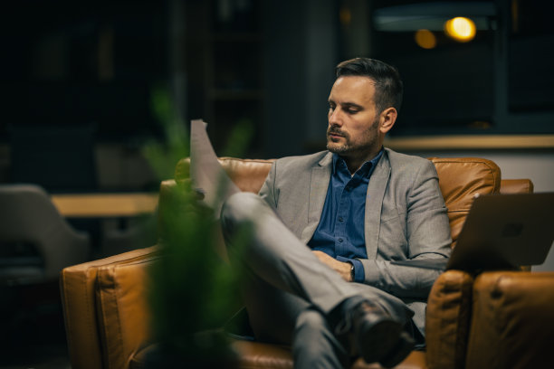 一个商人带着沉思和担忧的表情看着报纸图片下载