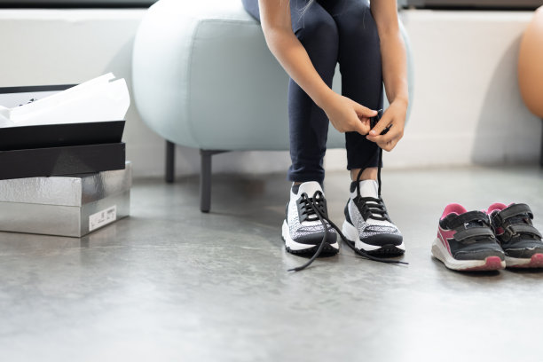 模糊的孩子的脸，手系鞋带，在商店里试穿运动鞋图片下载