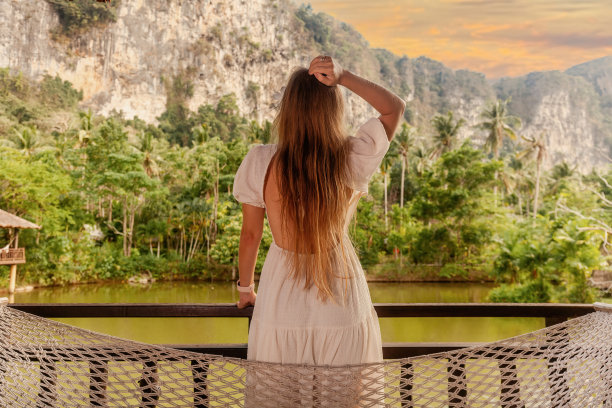 女人的后视图享受热带度假胜地与令人惊叹的山图片下载
