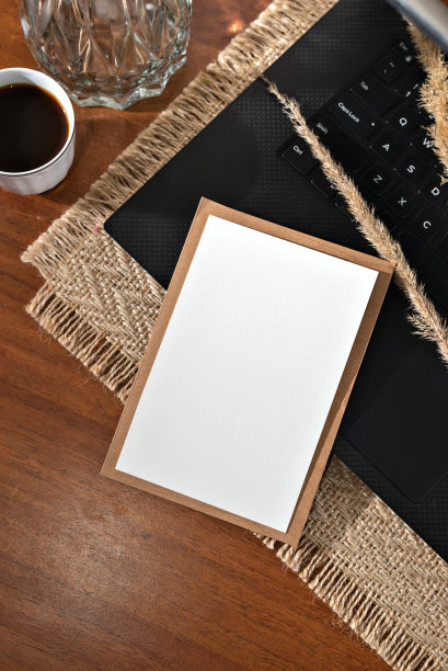 美学商业品牌模型，空白纸卡，笔记本电脑和咖啡杯在棕色木桌背景，模板与复制空间图片下载