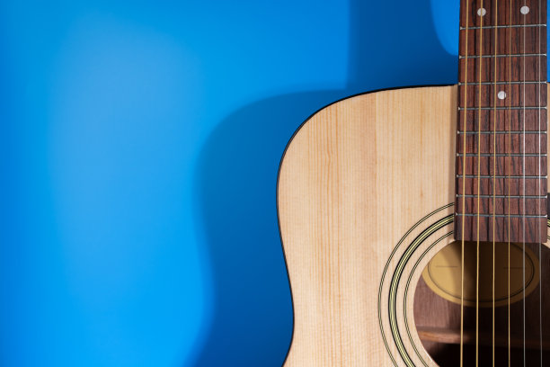 吉他，一个经典的乐器在蓝色的背景特写，学习旋律图片下载
