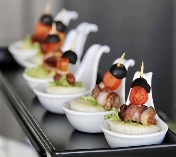 一盘食物的照片，上面有各种各样的开胃菜，几个小白碗，盘子上放着食物。图片下载