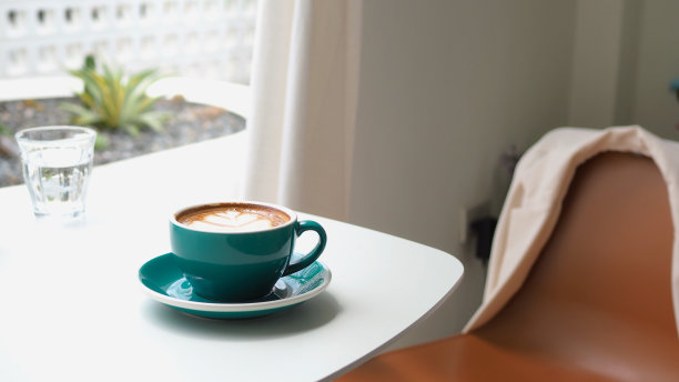 早上的一杯咖啡沿着窗户玻璃放在桌子上图片下载