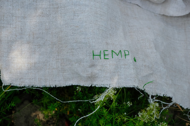 麻帆布上绣着麻字。草地的背景。图片下载