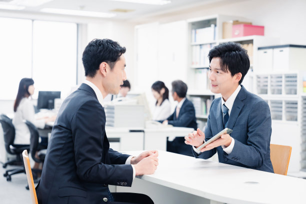 男性员工在柜台用平板电脑引导顾客图片下载