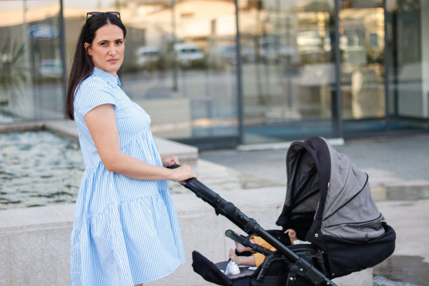 妈妈和宝宝走过城市的商业中心图片下载