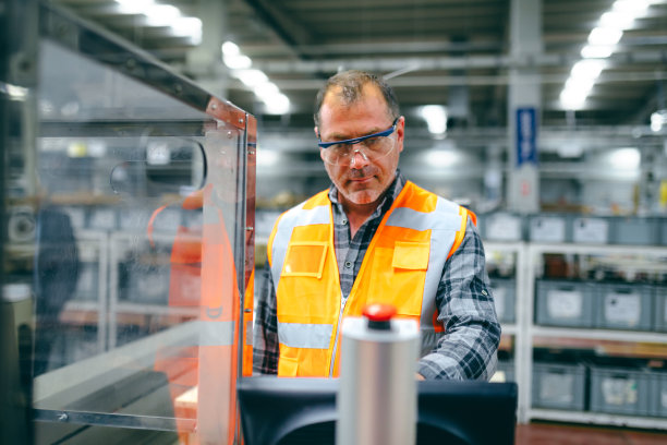 在工厂里操作制造设备的男性产业工人图片下载