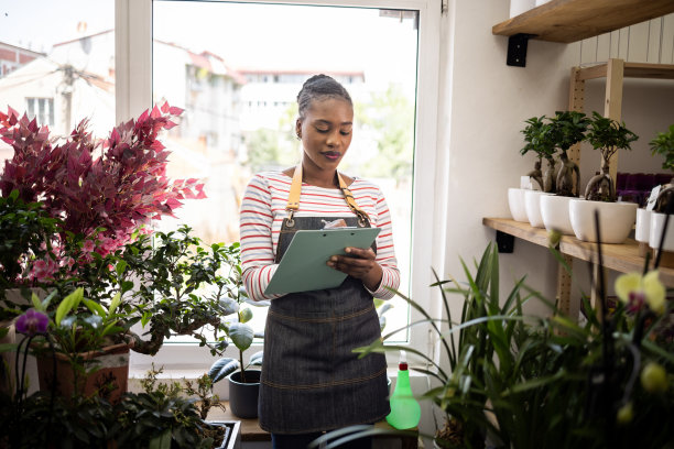 黑人女花店老板在店内清点盆景图片下载