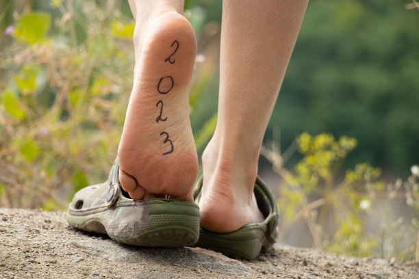 女人的腿上刻着2023的一脚，这就是攀登的山峰，一条新的道路，成功，前进图片下载