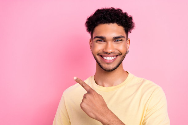 满意的乐观男子的肖像与非洲头发耳环胡茬指导空白空间推广孤立的粉红色背景图片下载
