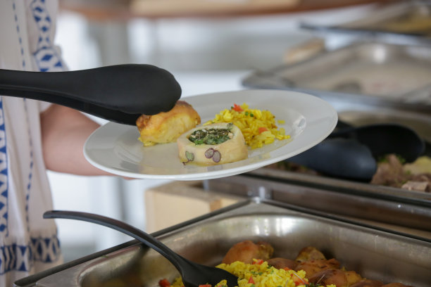 一名妇女在自助餐厅排队取食物图片下载