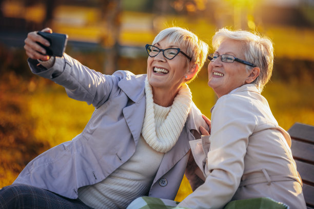 两个上了年纪的女人在五彩缤纷的公园里自拍图片下载
