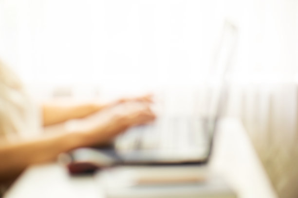 模糊的女性手在笔记本电脑上打字。图片下载