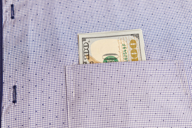 两张100美元的钞票在衬衫口袋里。经济学投资金融概念图片下载