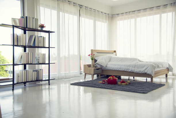 在温馨的装修室内模糊背景卧室。干净柔软的床，时尚的装饰，轻松的宿舍与复制空间。现代公寓白光新潮风格。室内背景模糊散焦图片下载