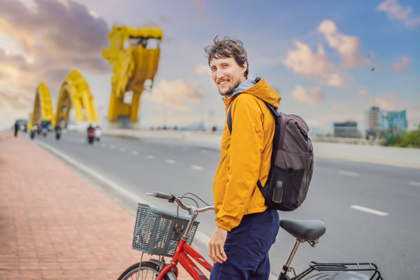 一名男子在岘港的龙桥上骑自行车图片下载