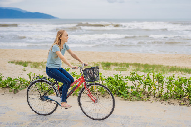 骑自行车的年轻女子在海边骑自行车图片下载