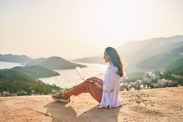 自由快乐的灵感自由职业者女孩享受远程工作的电脑在日落与美丽的景色。网上工作无处不在图片下载