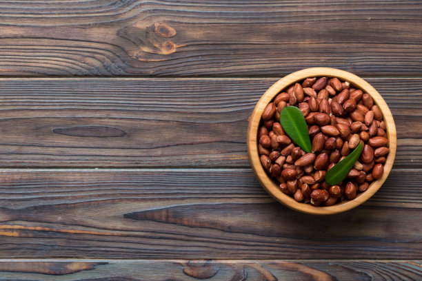 新鲜健康的花生在碗在彩色的桌子背景。健康饮食bertholletia概念。超级食物图片下载