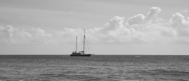 塞舌尔马埃岛东北角海岸附近过往帆船的黑白相间图片下载