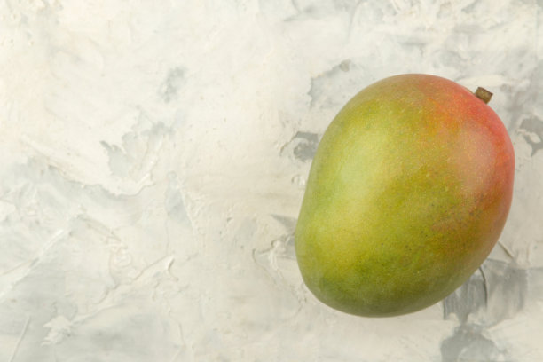 成熟的新鲜芒果，果片和叶子在浅色的背景下。热带水果。前视图。文本空间图片下载