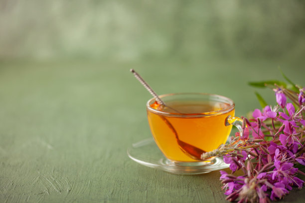 桌上的玻璃杯里装着草本杂草茶。另类医学概念图片下载