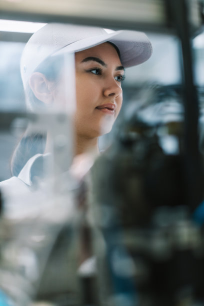 在工厂里操作制造设备的女工业工人图片下载