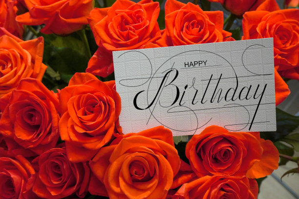 明信片上，网上挂着生日祝福的横幅，上面写着生日快乐的题词，一束鲜花上写着祝贺的字条图片下载