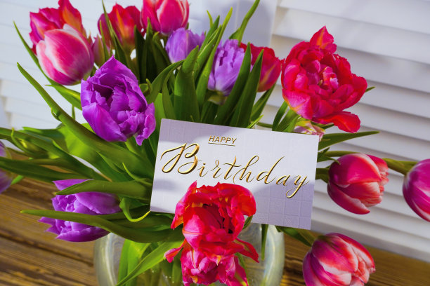 明信片上，网上挂着生日祝福的横幅，上面写着生日快乐的题词，一束鲜花上写着祝贺的字条图片下载