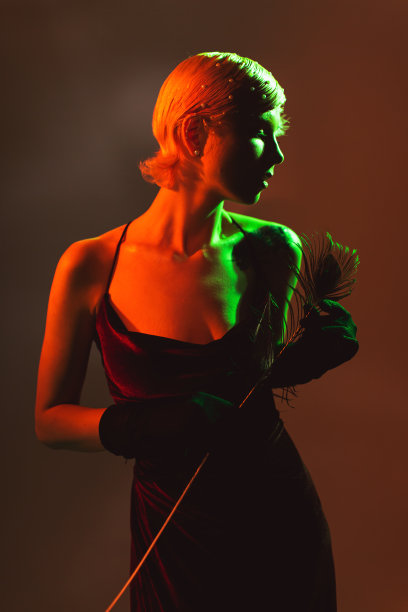 在霓虹灯下的工作室里，穿着复古连衣裙的金发时尚模特。美妆图片下载