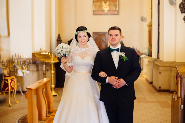 新娘穿着漂亮的礼服，手捧婚礼花束，手拿婚礼礼物图片下载