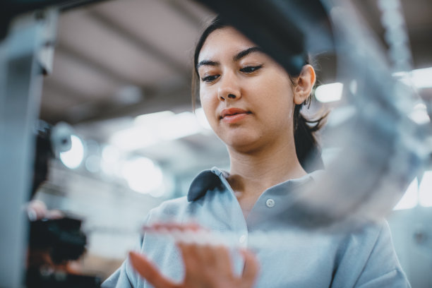在工厂里操作制造设备的女工业工人图片下载