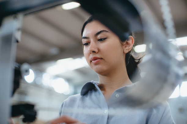 在工厂里操作制造设备的女工业工人图片下载