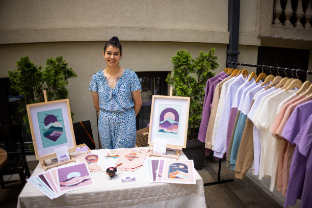 在艺术博览会上，一位年轻的白人女艺术家和她的艺术作品的肖像图片下载