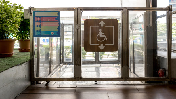 有标志的无障碍电梯。残疾人电梯附近的现代化公寓设施。在起居室入口处为残疾人准备的专用电梯。配有轮椅的设备。图片下载