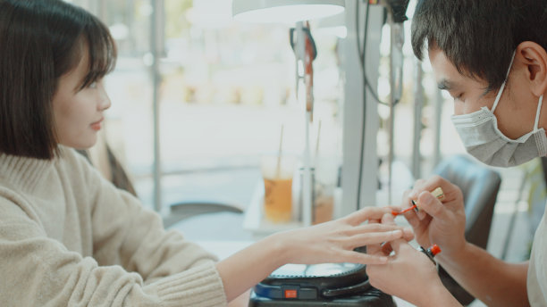 亚洲男性美容技师在美甲沙龙提供美甲服务图片下载