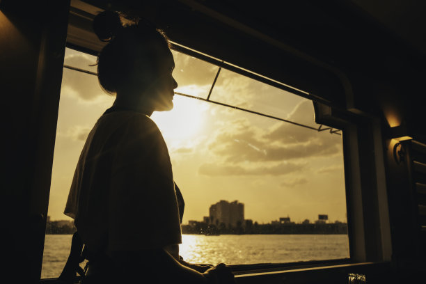 在尼罗河日落时分乘船旅行的快乐女人肖像（开罗）图片下载