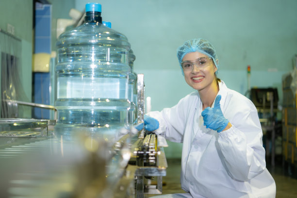 饮水厂品管女工在将饮水带导入水箱前检查水箱的质量图片下载
