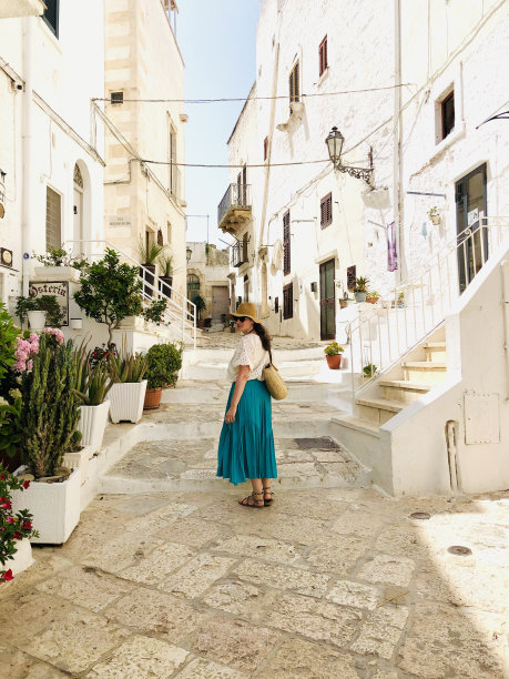 穿绿裙子的女人在普利亚的奥斯图尼游荡图片下载