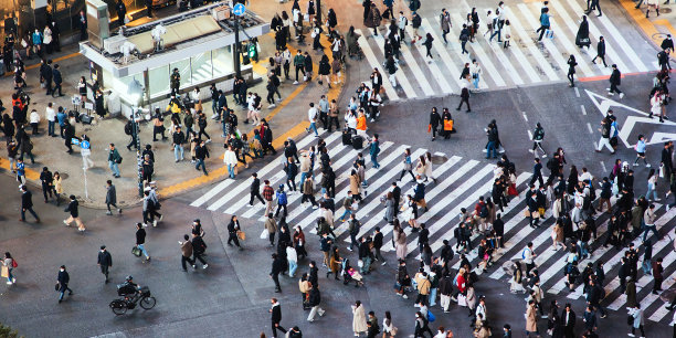 在东京涩谷，一群日本人、亚洲游客、行人在夜晚穿过马路。日本旅游景点，旅游地标，亚洲交通城市生活理念图片下载