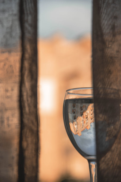 高层建筑背景窗边的一杯水图片下载