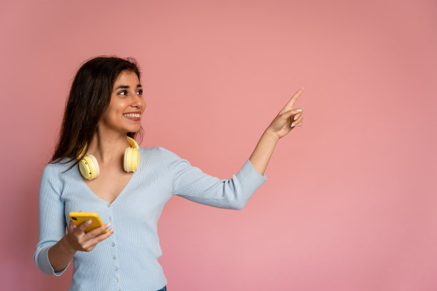 一个拿着手机指着旁边的女人。图片下载