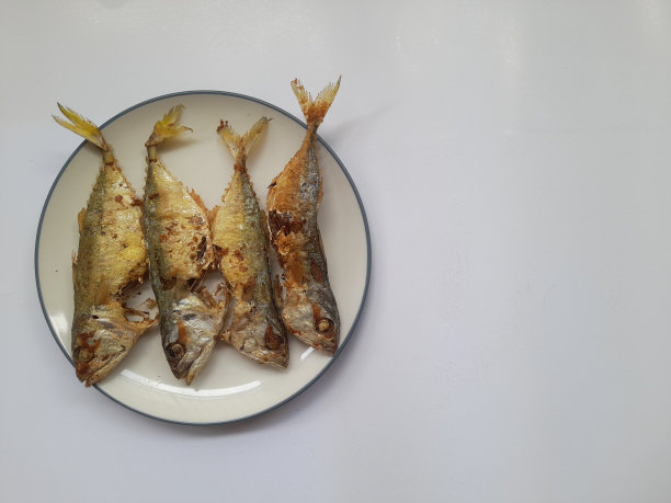 油炸鲭鱼食品(ikan kembung)在白色背景上的盘子顶部视图图片下载