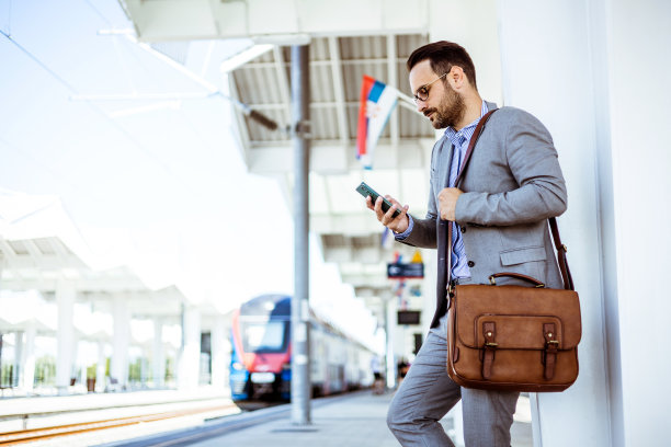 商人在火车站使用手机。图片下载