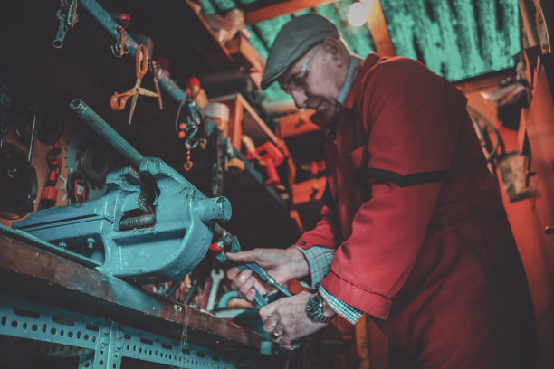 成熟的人在虎钳上用力拧紧管子图片下载